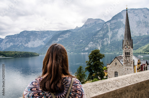 Frau schaut auf Kirchturm in Hallstatt mit Hallstätter See im Hintergrund