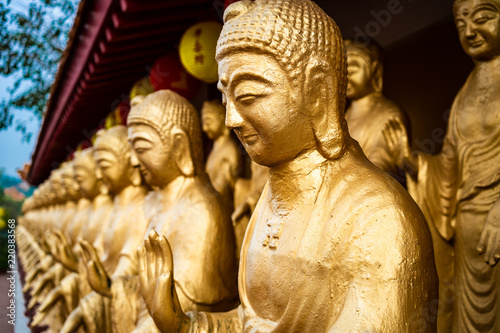 Close-up view of statues of golden standing Buddha at Fo Guang Shan Monastery Kaohsiung Taiwan
