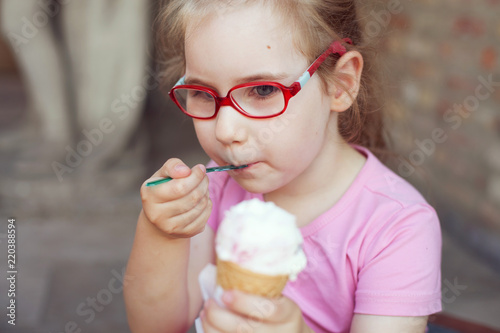 girl in pink dress eating ice cream