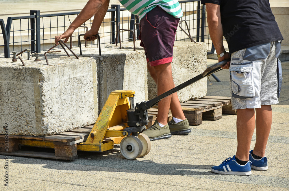 Men are working with a manual forklift Men are working with a manual forklift