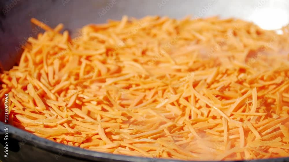 Carrots cooking outdoor. Process preparing camping food on burning fire while hiking to wild nature Carrots cooking outdoor. Process preparing camping food on burning fire while hiking to wild nature