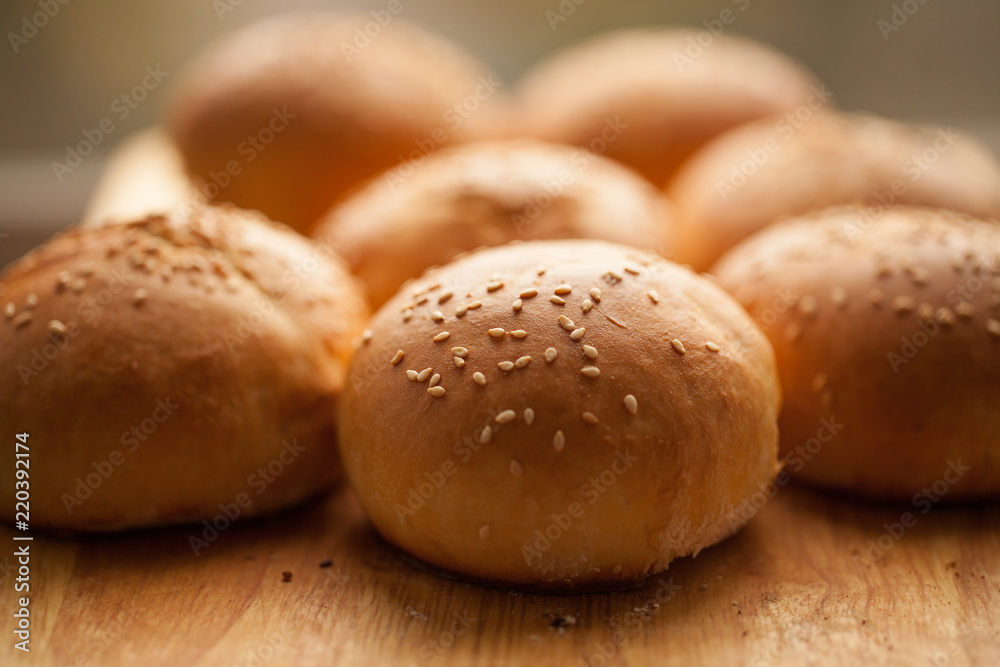 background of homemade buns with sesame seeds for hamburgers. made at home bread. natural product.