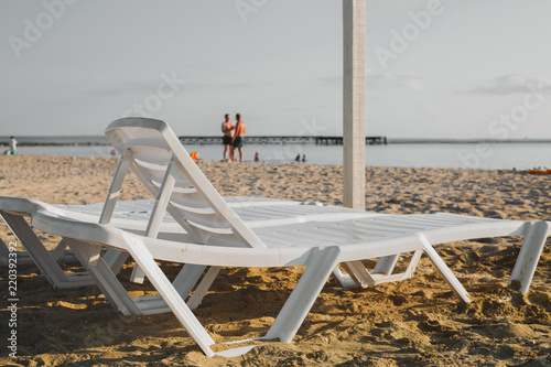 Empty beach with blue sea and beach beds in the morning photo