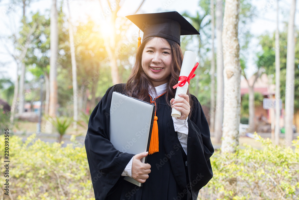 Beautiful Attractive Women Student Graduate holding certificate and computer laptop in her hand,feeling so proud and happiness in Commencement day Beautiful Attractive Women Student Graduate holding certificate and computer laptop in her hand,feeling so proud and happiness in Commencement day