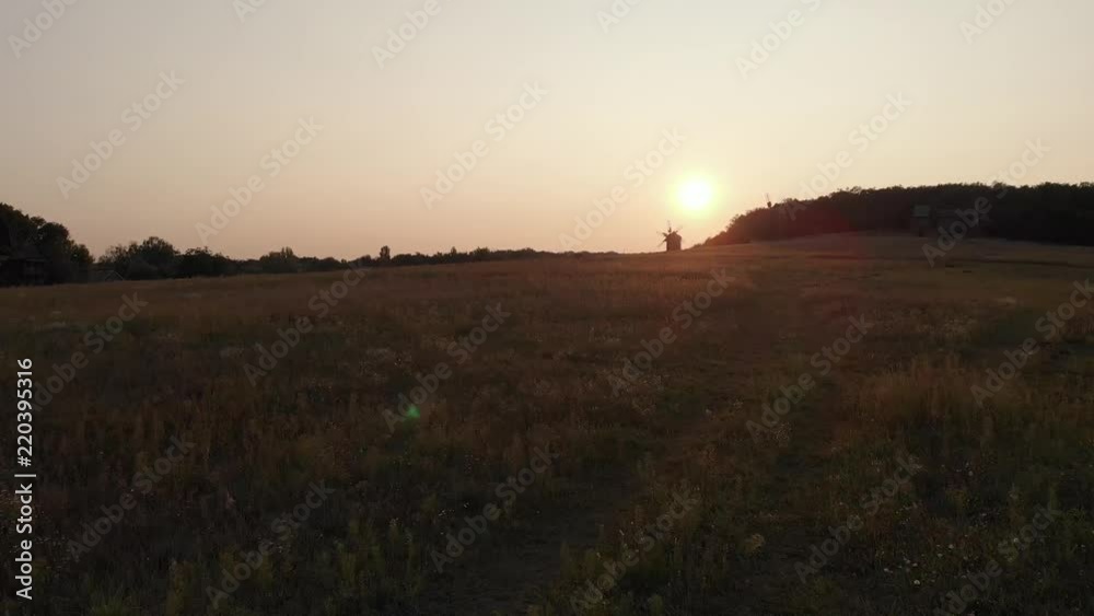 Shooting in the field at sunset in September. In the background of the mill. Shooting from a drone. Shooting in the field at sunset in September. In the background of the mill. Shooting from a drone.