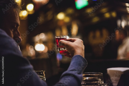 man holds  glass of alcohol in his hand