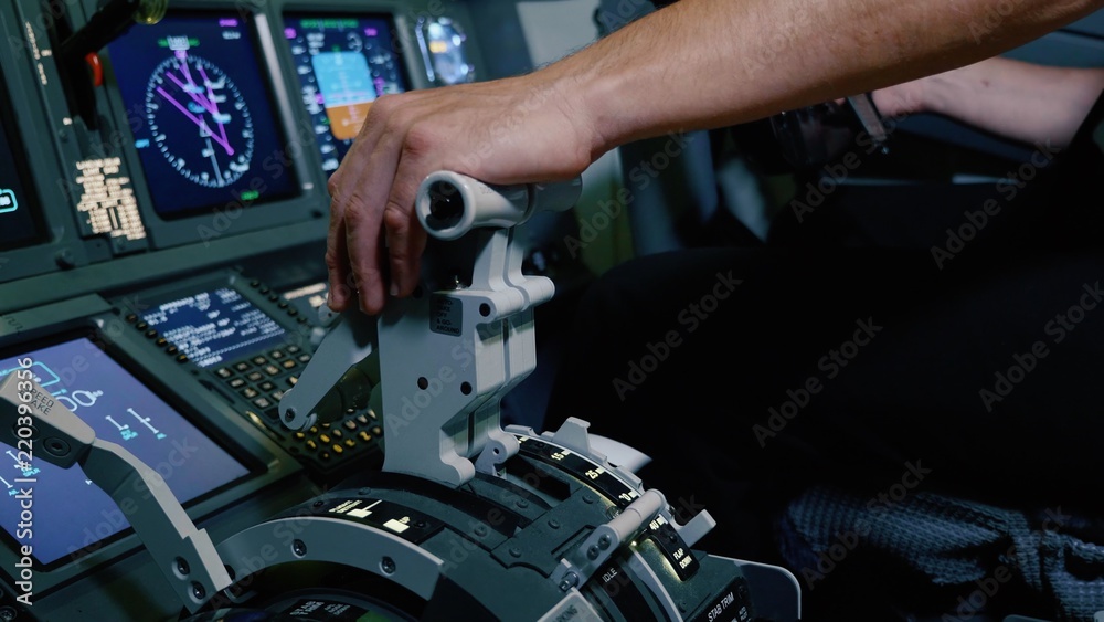 Pilot holding hand on the thrust lever handle for engine control of airliner. Pilot holding hand on the thrust lever handle for engine control of airliner.