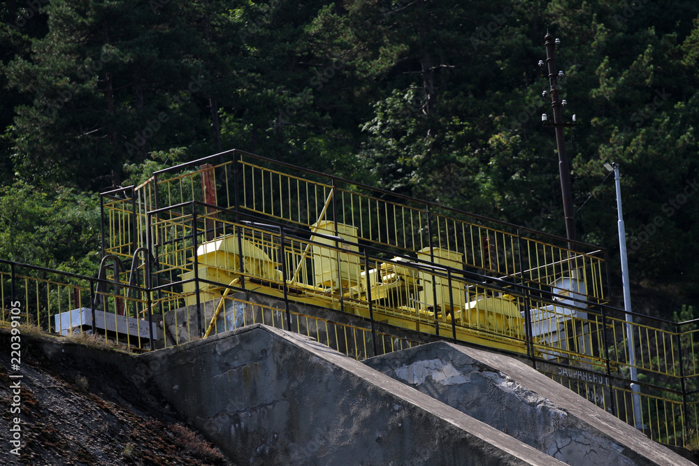 Dam wall and overflow of Iskar Dam. Water flowing over a dam wall. Mist rising above the Iskar dam wall. Cascade from a hydroelectric plant. Lake water release. Water plums on hydropower station.