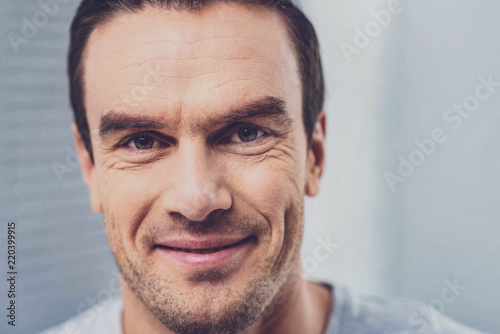 Hazel-eyed man. Hazel-eyed handsome man feeling extremely happy smiling broadly while looking at his beloved