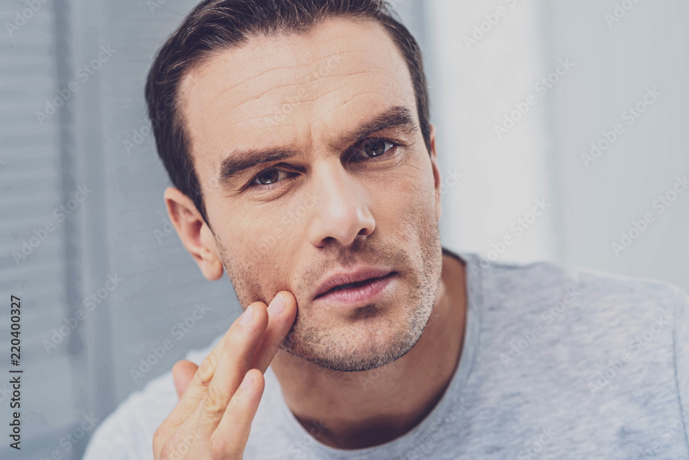 Thoughtful man. Handsome mature dark-haired man wearing stylish grey shirt feeling thoughtful after long busy day Thoughtful man. Handsome mature dark-haired man wearing stylish grey shirt feeling thoughtful after long busy day