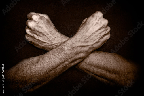 Foto Man's crossed arms as a defense or shield to protect the body
