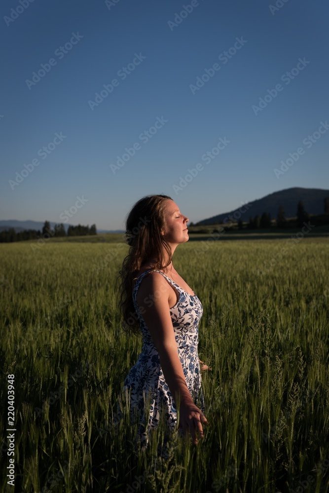 Woman standing with eyes closed in the field Woman standing with eyes closed in the field