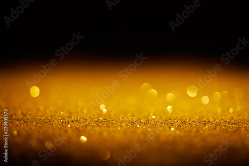 sparking gold glitter with bokeh on black background