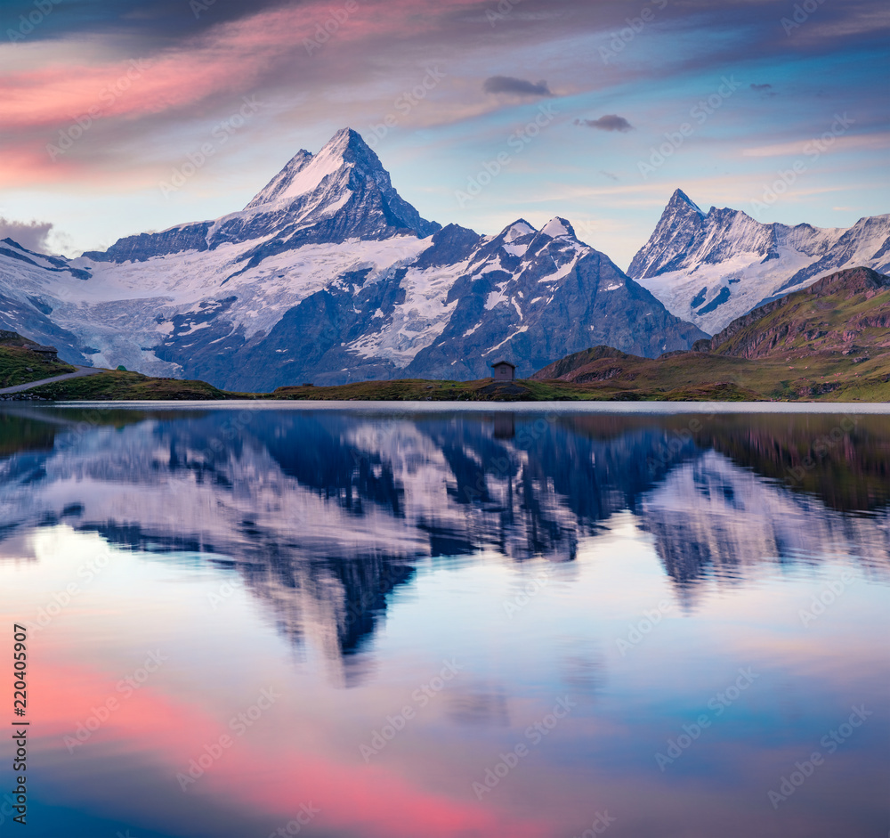 Colorful summer sunrise on Bachalpsee lake with Schreckhorn peak on background.