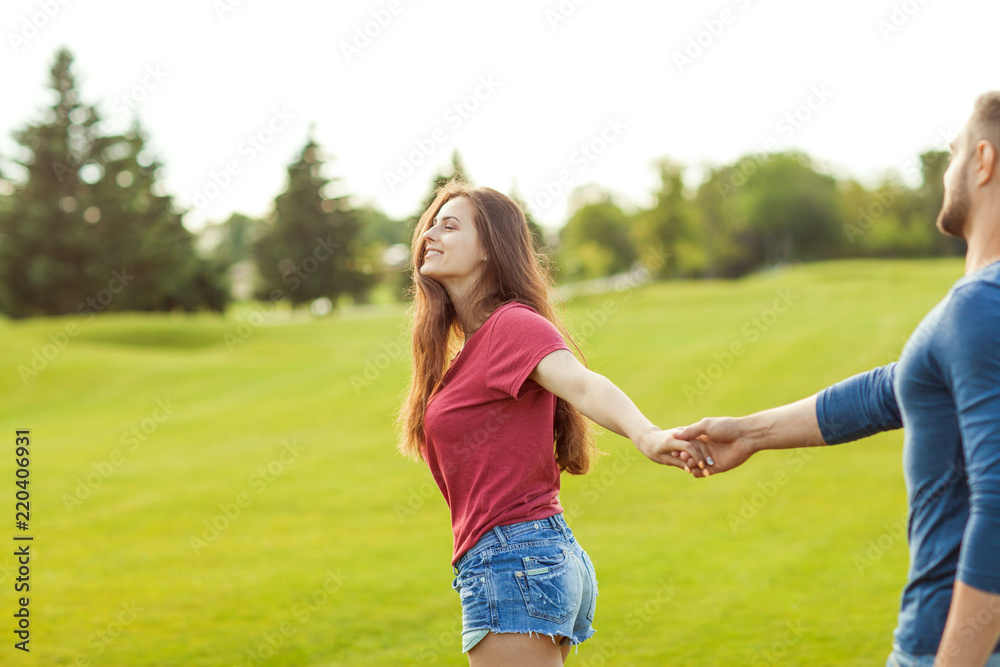 man in love holding the hand of a girl and they walk in the park