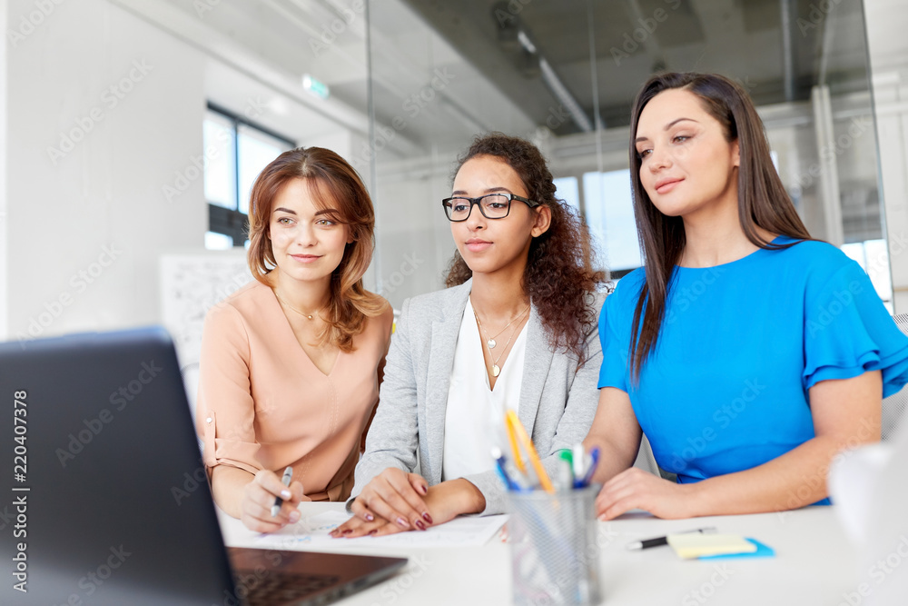 Fototapeta premium business, teamwork and people concept - female team or businesswomen with laptop computer working at office