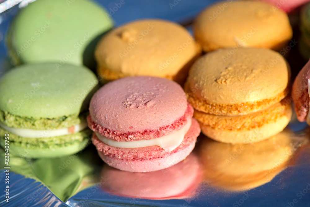 French cake macaron or macaroon at picnic outdoors. Colorful cookies made from almond flour in pastel colors. 