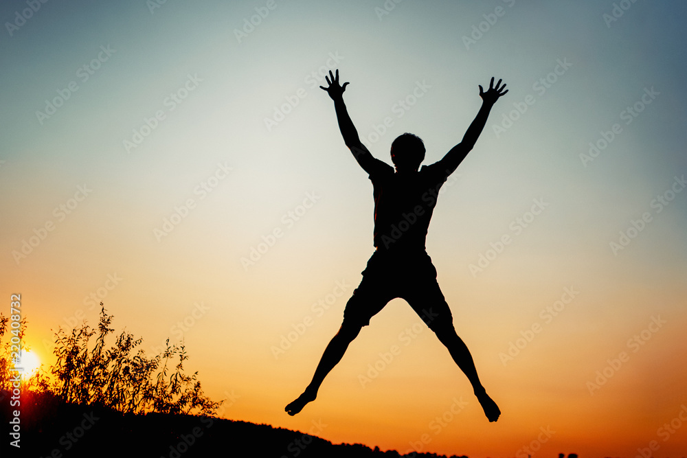 Happy man jumping for joy at sunset. Success and happiness concept Happy man jumping for joy at sunset. Success and happiness concept