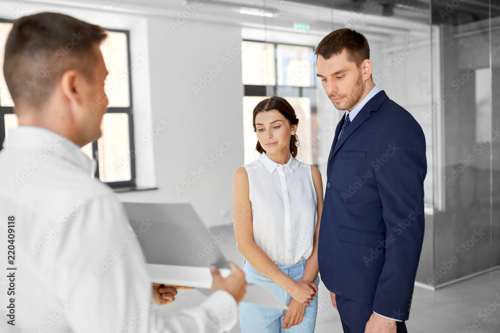 Fototapeta premium real estate business, sale and people concept - happy smiling realtor with folder showing documents to customers at new office room
