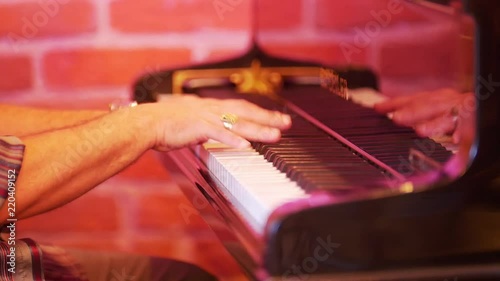 A man plays the piano keys. In the frame of men's hands. On the fingers gold rings. photo