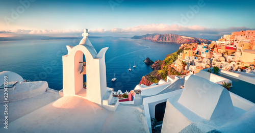 Sunny morning panorama of Santorini island. Picturesque spring sunrise on the famous Greek resort Fira, Greece, Europe. Traveling concept background. Artistic style post processed photo.