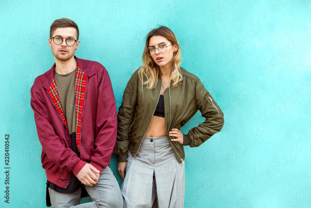 fashion couple standing posing near blue wall fashion couple standing posing near blue wall