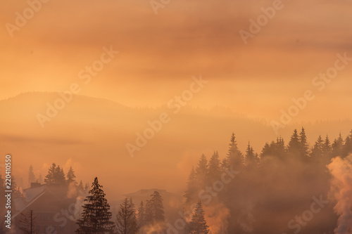 Colorful autumn morning in the Carpathians. Dramatic sunrise in the mountain village. Artistic style post processed photo.