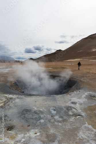 hverir geothermal area in iceland, active mud pod with steam and people in background