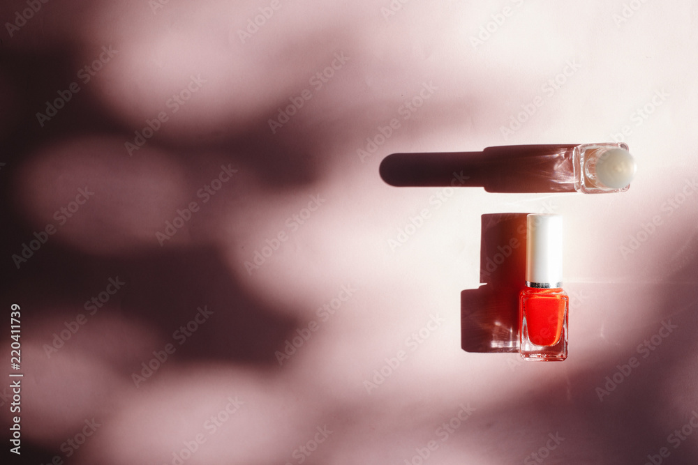 multi-colored nail polishes on pastel pink background, top view, Flat lay. Many round jars with multi-colored for nail polish. multi-colored nail polishes on pastel pink background, top view, Flat lay. Many round jars with multi-colored for nail polish.