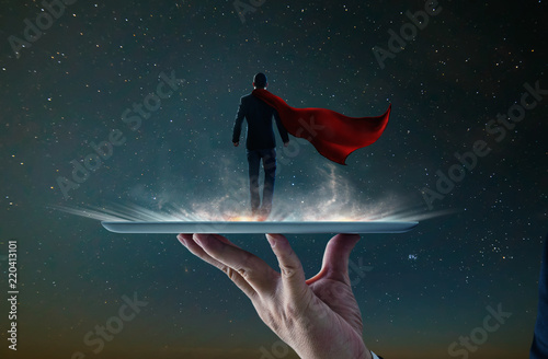 Waiter hand holding an empty digital tablet with Businessman in a suit and cape hero ,victory concept.