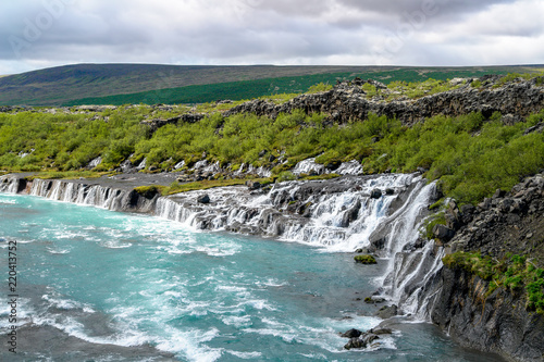 Hraunfossar waterfalls - Western Iceland. The water seems to appear from the lava but is a spring that surges through the ground and runs in rapids into the Hvita River.