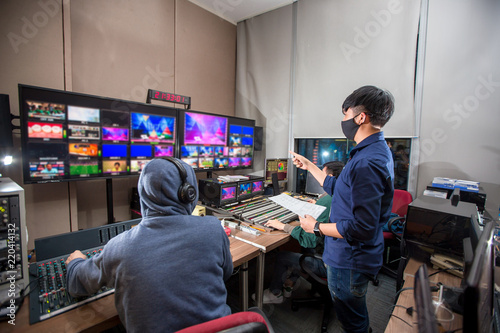 Behind the televised broadcast in the control room, live in the control room. Producer looking at the chart list.