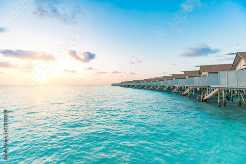 Fototapeta Naklejka Na Ścianę i Meble -  Beautiful villas over water on tropical island resort in Maldives with turquoise sea and sunset,Vacation in holiday relax with nature in summer