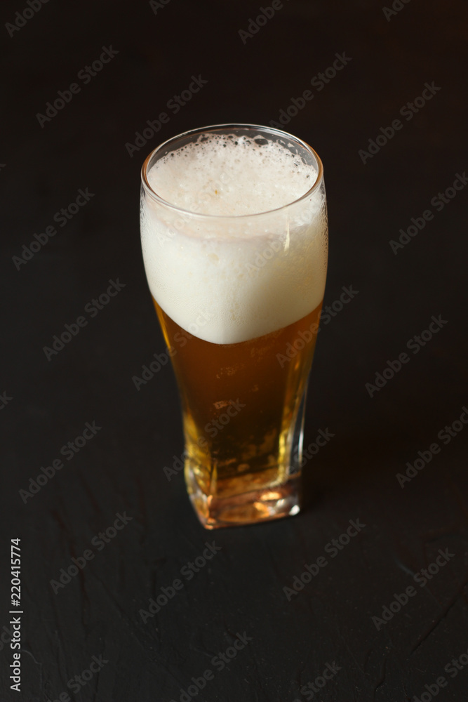 Light beer in a glass bowl on a black background. Beer in the bar Light beer in a glass bowl on a black background. Beer in the bar