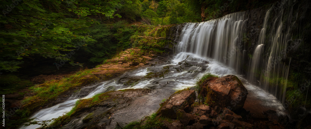 Fototapeta premium Sgwd Isaf Clun-gwyn panorama The top section of Sgwd Clun Gwyn waterfall from the west bank, on the Mellte river, near Pontneddfechan in South Wales, UK. 