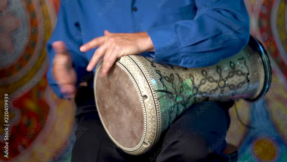 Doumbek drumming slow rhythm with arabic background.