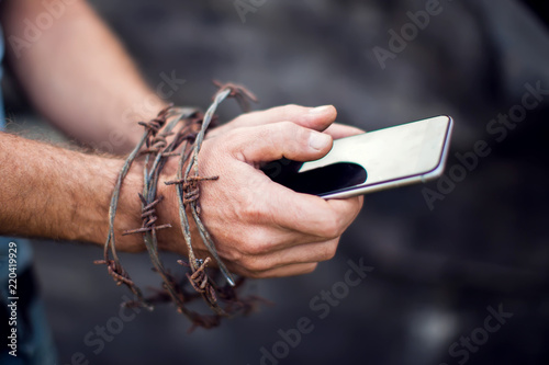 Konstfotografi Smartphone with barbed wire on a dark background