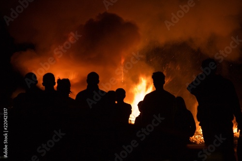 Bush fire blazing with people standing around silhouetted by the flames. Dangerous in summer in california. Wildfire risk © Kyla