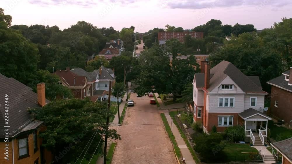 An ascending shot of a road that runs through a residential area by a river.