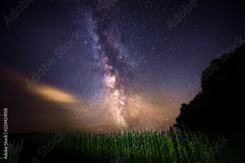 Milky way stacked with forrest an field, real colors, made in austrian upperaustria at night, stars and galaxies on the sky