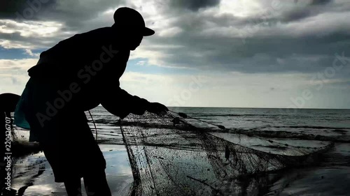 4K high definition cinematic video of a fisherman pulling fishnets from the sea