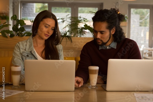 Wallpaper Mural Couple discussing over laptop in cafe Torontodigital.ca