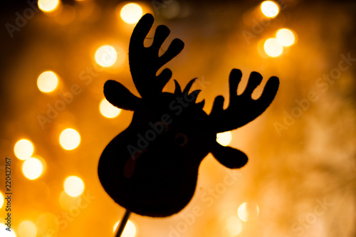 Toy deer on the background of New Year's lights