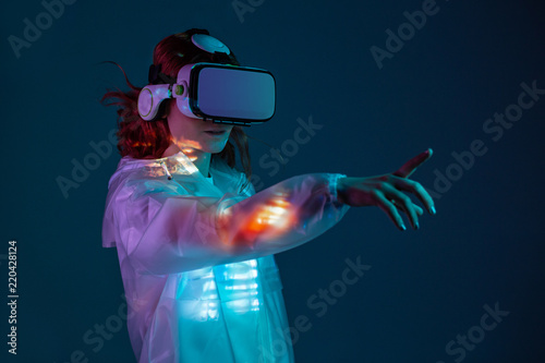 Woman touching air in VR glasses photo