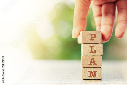 Hand putting the wooden toy with word PLAN for business plan concept photo