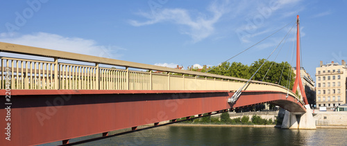 red suspension footbridge over the Saone river