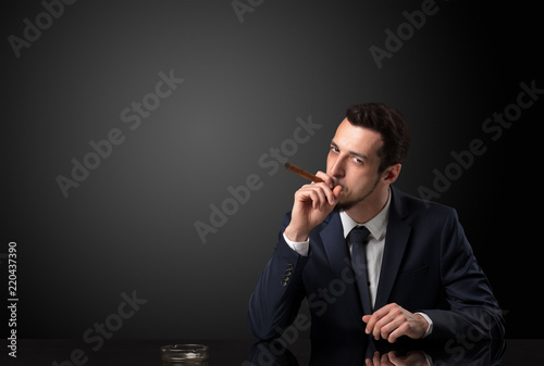 Businessman holding cigarette in his hand and wearing suit.