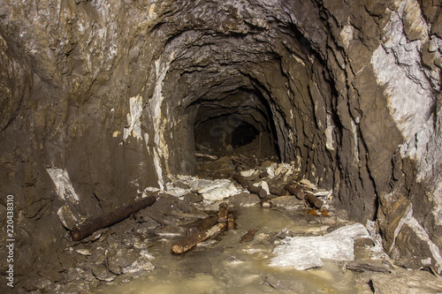 Underground abandoned gold iron ore mine shaft tunnel gallery passage with timbering wooden