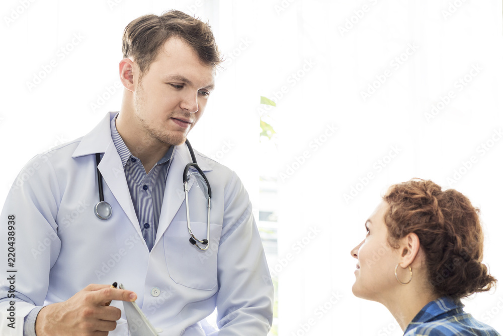 Medical professionals caucasian man reassuring and talking with young woman stress patient.Close up and copy space. Medical professionals caucasian man reassuring and talking with young woman stress patient.Close up and copy space.