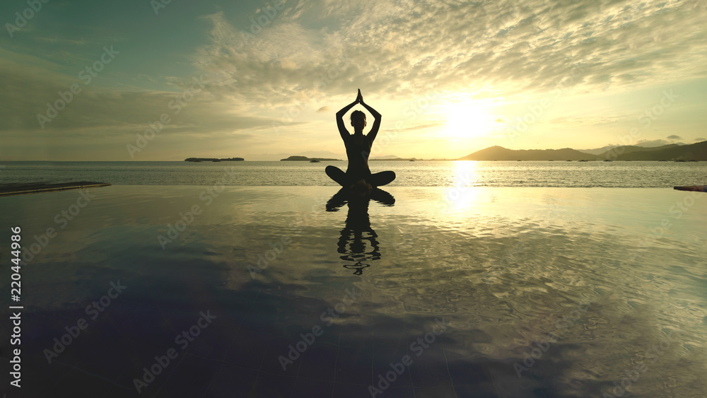 Unknown woman meditating on the beach